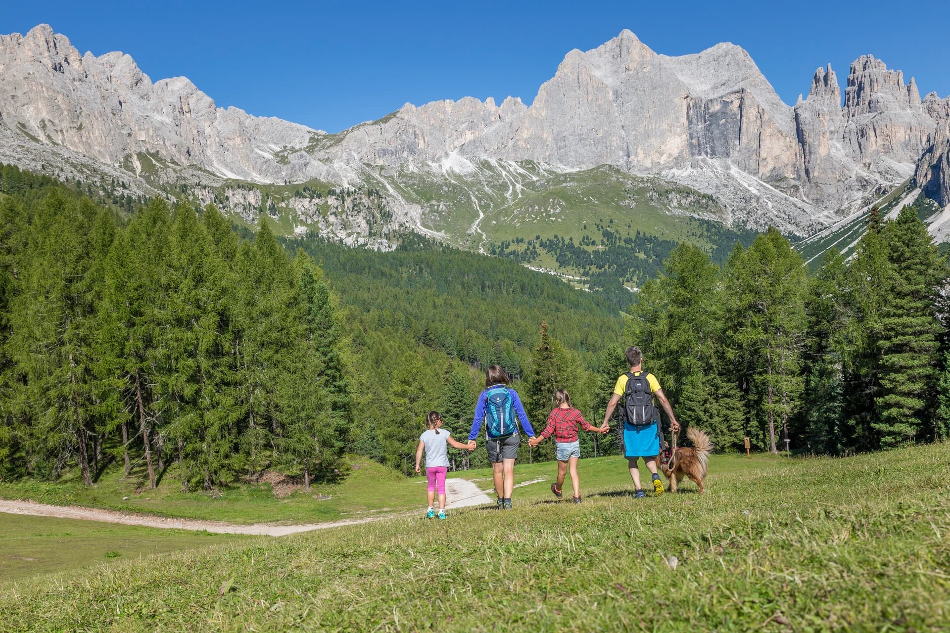 Famiglia con bambini in passeggino sul sentiero verso il Lago di Carezza